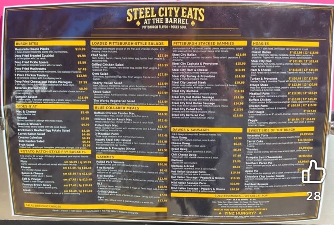 Steel City Eats at the Barrel menu board listing Burgh Bites, Sides N’at, Potato Patch-style fry baskets, loaded Pittsburgh-style salads, Blue-Collared Meals, Sammies, Pittsburgh Stacked Sammies, Dawgs and Sausages, Hoagies, Sweet Side of the Burgh and cold beverages